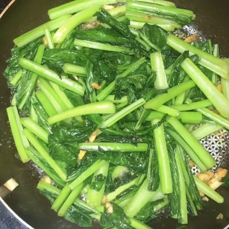 Thực hiện cách xào rau cải ngọt trong chảo nóng với tỏi phi thơm