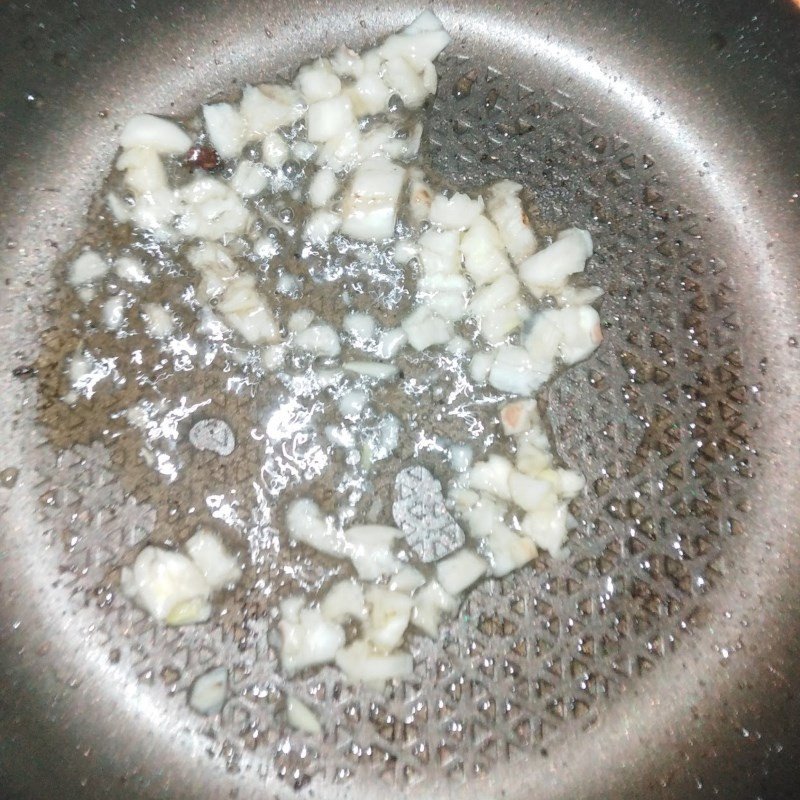 Thực hiện cách xào rau dớn ngon với tỏi phi thơm trên chảo nóng