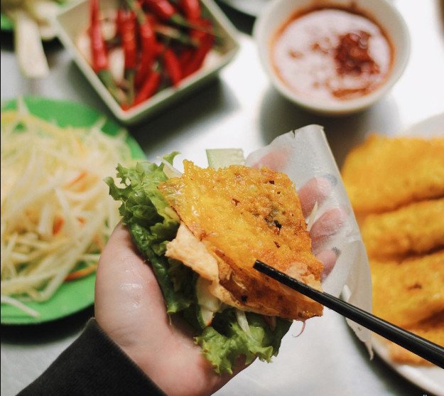 Thưởng thức bánh xèo giòn rụm cuốn cùng rau sống tươi mát, đúng điệu.