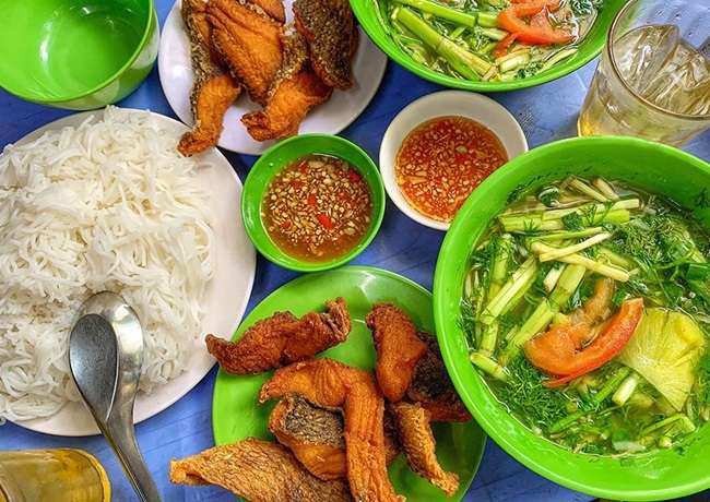 Tô canh bún cá chấm với rau cải, rau cần, hành và thì là