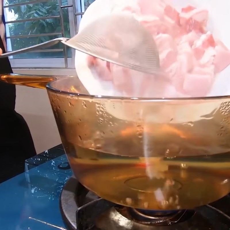 Trần thịt ba chỉ qua nước sôi để khử mùi hôi, bước quan trọng khi làm thịt kho tàu miền Bắc