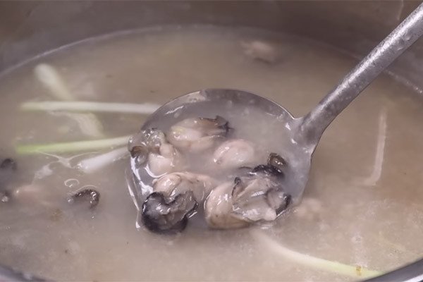 Trình bày cháo hàu với hành lá, hành phi và tiêu xay để thưởng thức