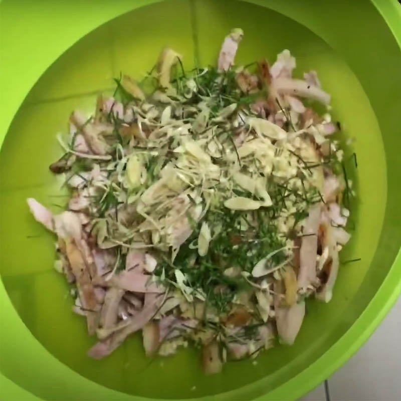 Trộn đều thịt lợn áp chảo với riềng, sả, lá chanh và gia vị trong thau lớn