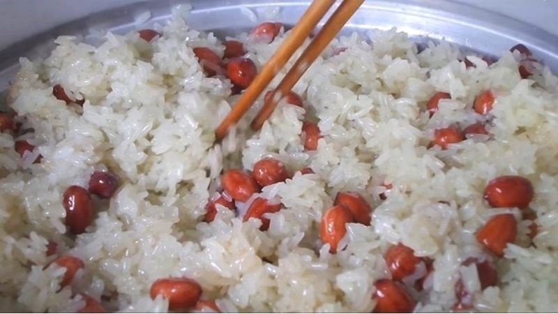 Trộn đều xôi đậu phộng trong nồi cơm điện để xôi chín đều và tơi xốp