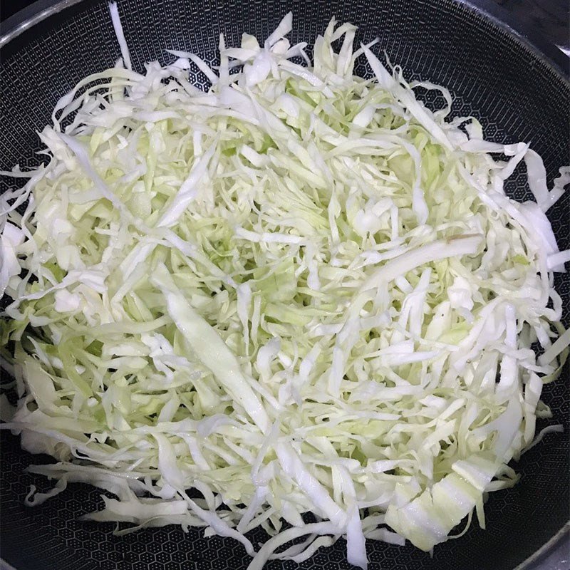 Trứng gà được đánh tan và thêm vào chảo bắp cải đang xào