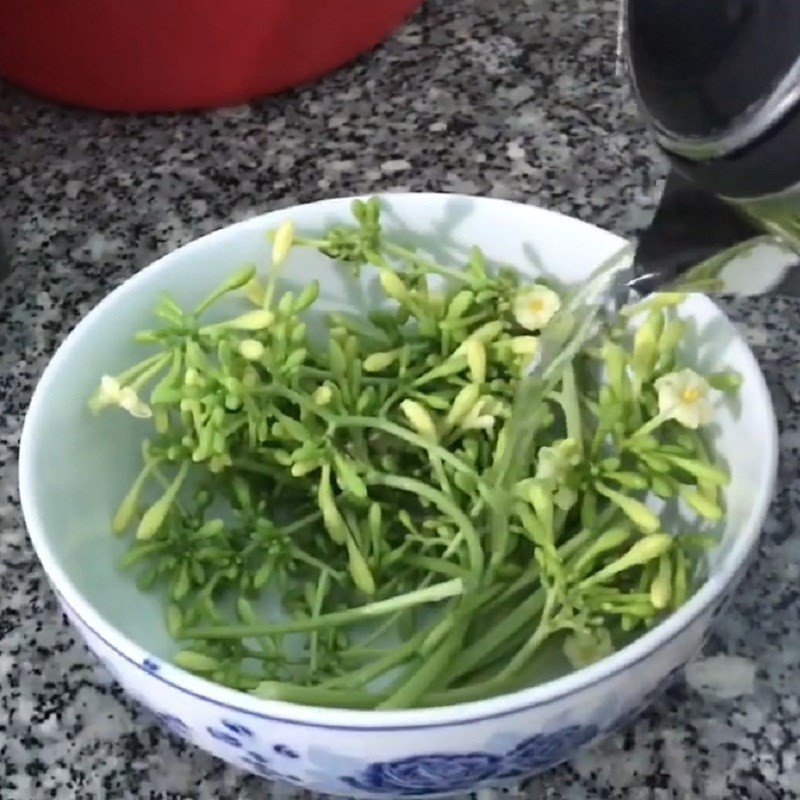 Trụng hoa đu đủ đực trong nước sôi để loại bỏ vị đắng