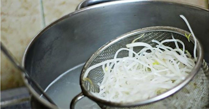 Trụng sợi hủ tiếu khô để có độ mềm và dai