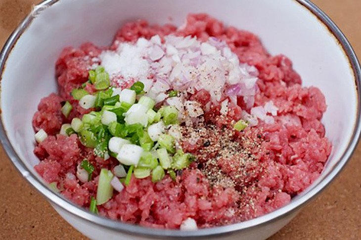 Ướp thịt bò băm với gia vị đậm đà, sẵn sàng để cuộn mỡ chài