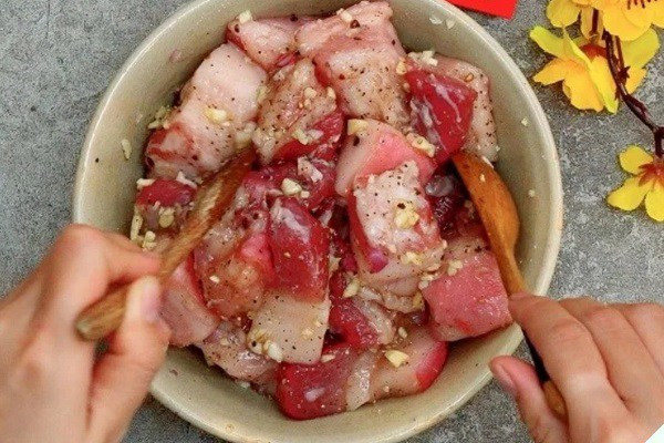 Ướp thịt với gia vị chuẩn bị làm thịt kho tàu