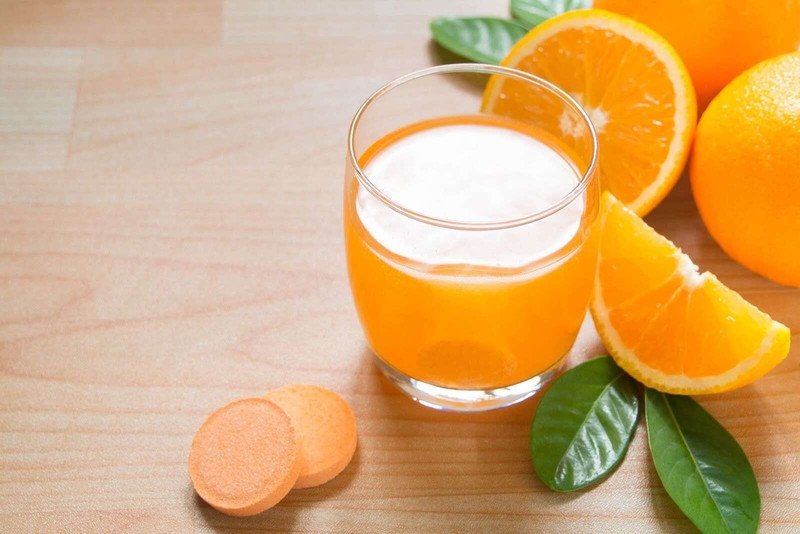 Viên vitamin C sủi bọt đang tan trong ly nước, minh họa thắc mắc về lượng calo