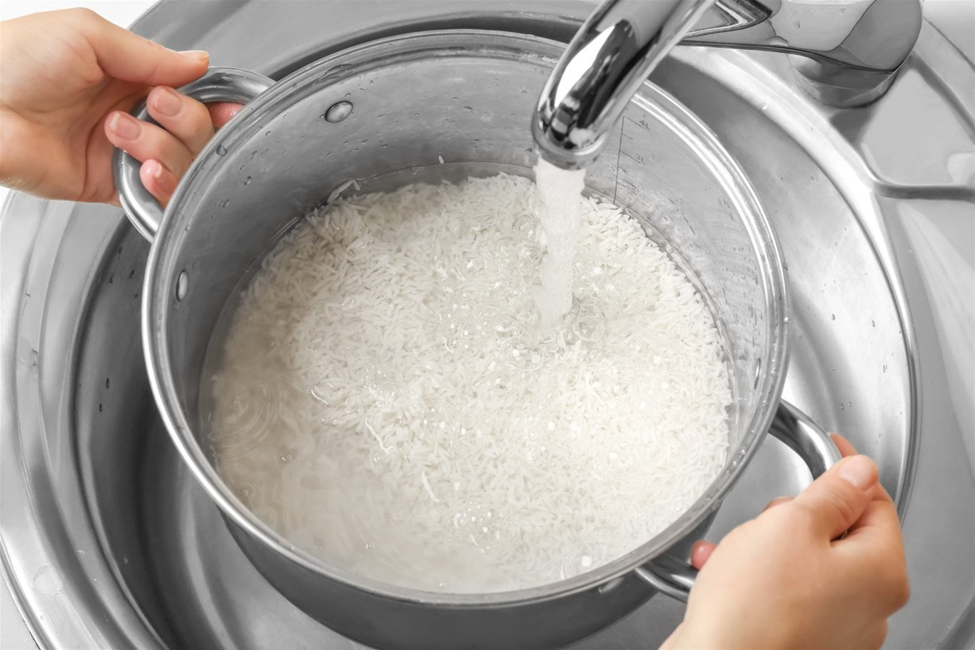 Vo gạo và đong nước để nấu cơm trên bếp từ
