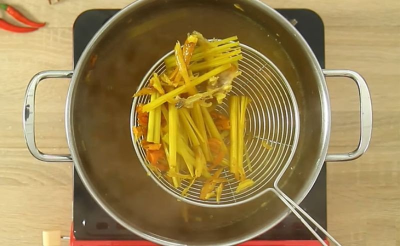 Vớt bã gia vị từ nước dùng bún cá