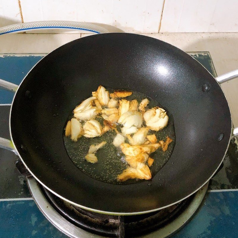 Xào hoa thiên lý trên chảo nóng cùng tỏi phi vàng thơm, bước quan trọng để có món xào ngon