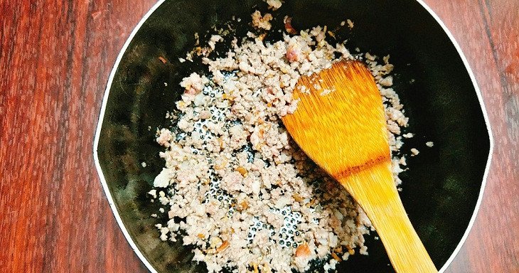 Xào thịt băm và hành lá trên chảo để tạo phần nhân đậm đà cho món bánh tráng mắm ruốc