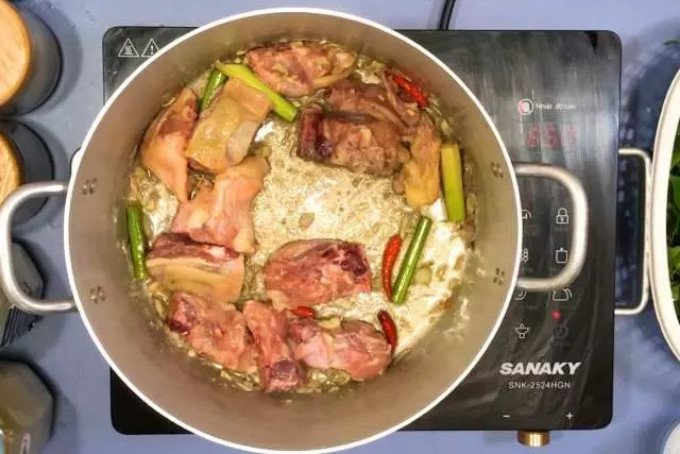 Xào thịt gà đã ướp cùng tỏi và sả thơm lừng trước khi nấu lẩu