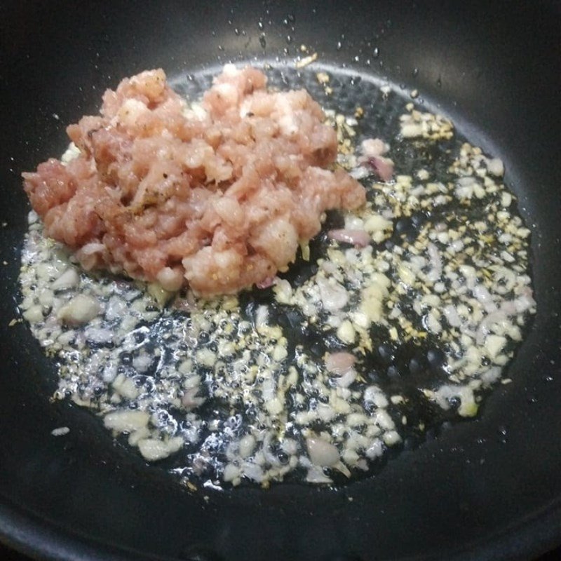 Xào thịt heo trên chảo để có nhân bánh tráng lụi thơm ngon
