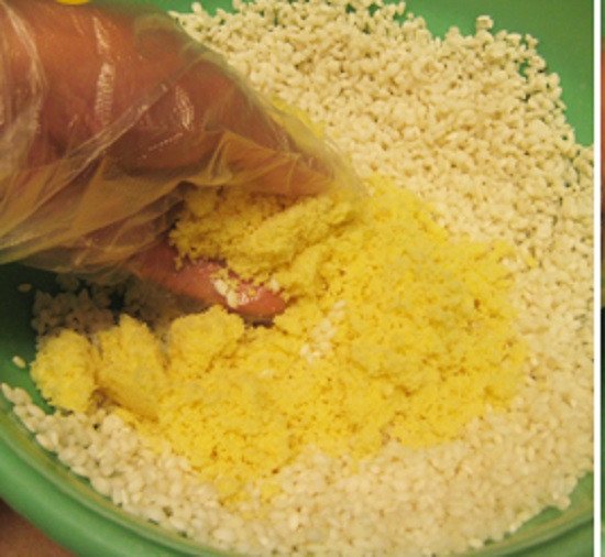 Xôi đang được trộn đều với nước cốt dừa béo ngậy, tạo hương vị đặc trưng của xôi vò miền Nam