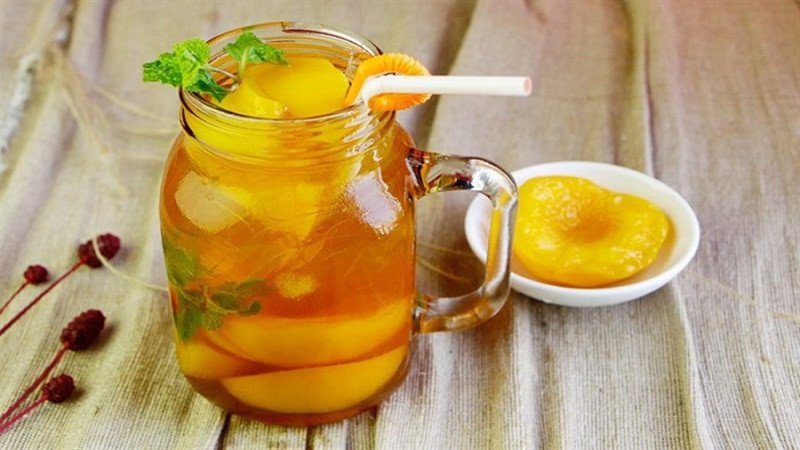 Ly trà đào mỏ quạ mát lạnh với những lát đào mỏ quạ và lá bạc hà, gợi ý món đồ uống giảm cân từ đào.