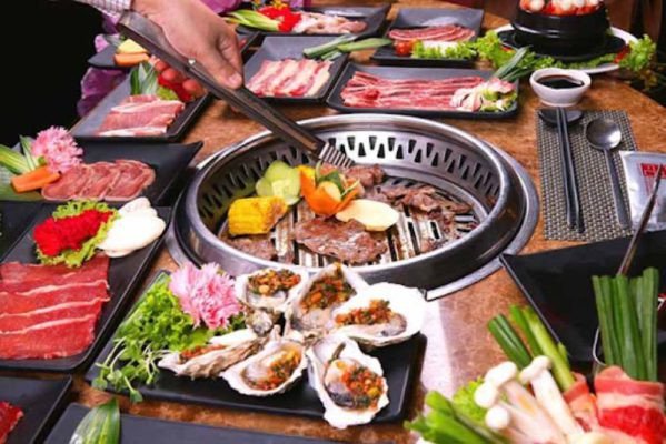 Một đĩa đầy ắp thịt nướng với rau xanh, biểu thị lượng calo đáng kể của một bữa ăn đồ nướng no.