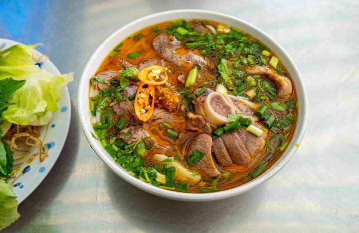 Một tô bún bò Huế đầy đặn với thịt bò, chả, rau sống tươi ngon