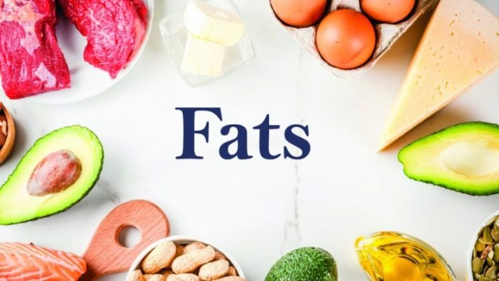 Người phụ nữ cầm trái bơ và các loại hạt, minh họa nguồn lipid lành mạnh