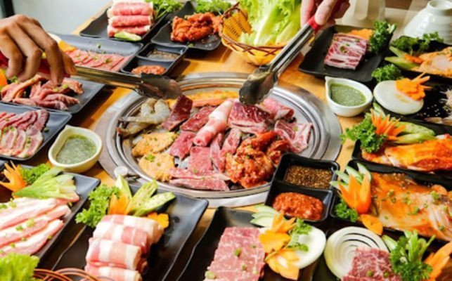 Người phụ nữ đang nướng thịt trên bếp than, minh họa những sai lầm thường gặp khi chế biến đồ nướng.
