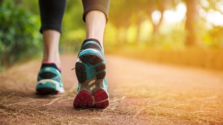 Người phụ nữ trẻ đi bộ trong công viên, minh họa lượng calo đốt cháy khi đi 1000 bước
