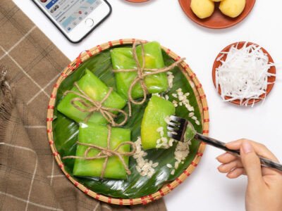 Những chiếc bánh cốm Hà Nội tươi ngon đặt trên lá chuối, thể hiện lượng calo trong bánh cốm cần được cân nhắc.