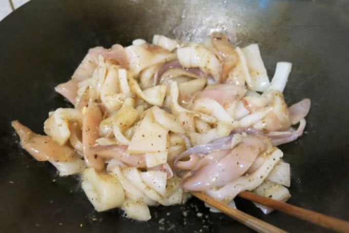 Quá trình xào mực với hành tây và các loại rau củ trên chảo