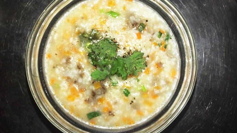 Tô cháo nóng hổi nấu từ cơm nguội với hành ngò và tiêu