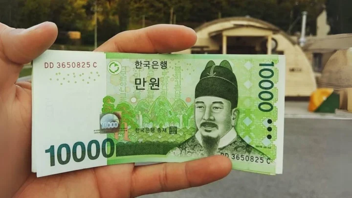 10000 Won Bằng Bao Nhiêu Tiền Việt Nam 2026 Mới Nhất? Hình ảnh nhân viên ngân hàng thực hiện giao dịch đổi tiền Won